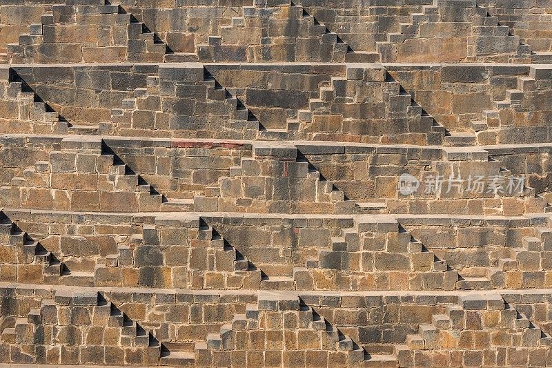印度拉贾斯坦邦Abhaneri Chand Baori阶梯井的石楼梯背景透视图。梯级井，通过一组梯级下降到水平面到达水的井